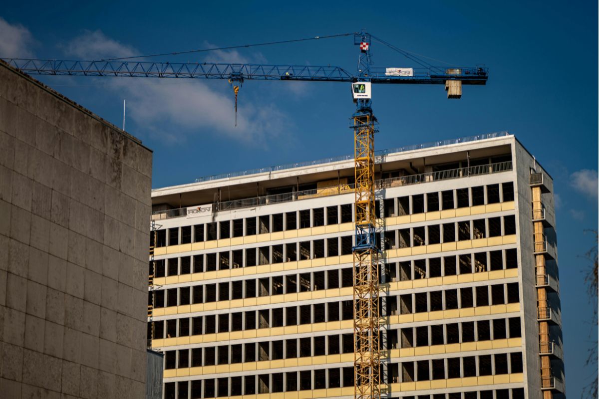 Bouwen Bouwproject met hijskraan en moderne utiliteitsbouw binnen stedelijke ontwikkeling.