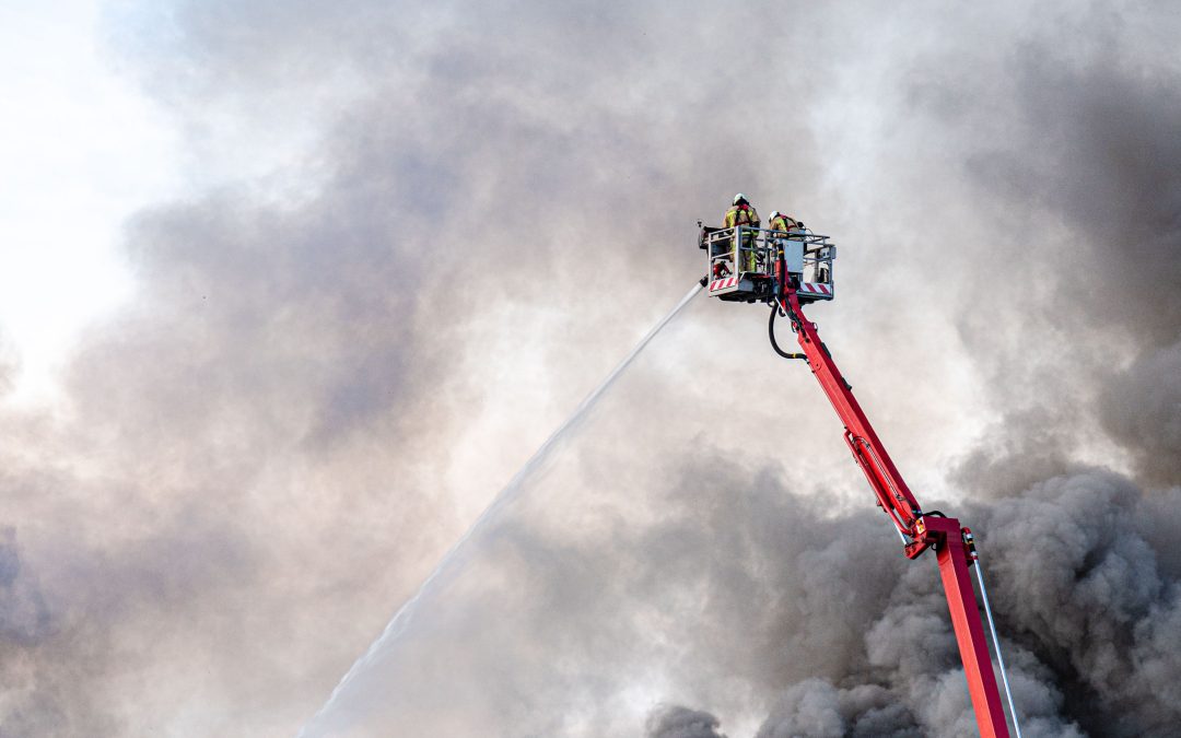 Industriële bedrijfsbrand met grote vlammen en rookontwikkeling. Het artikel behandelt milieugevolgen, brandveiligheid en vergunningseisen voor bedrijven.