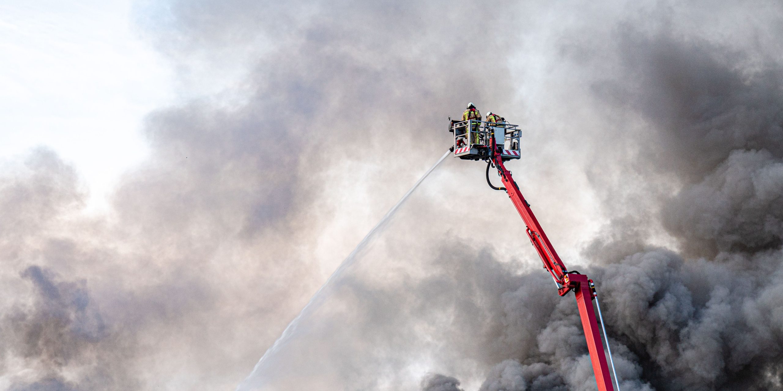 Industriële bedrijfsbrand met grote vlammen en rookontwikkeling. Het artikel behandelt milieugevolgen, brandveiligheid en vergunningseisen voor bedrijven.