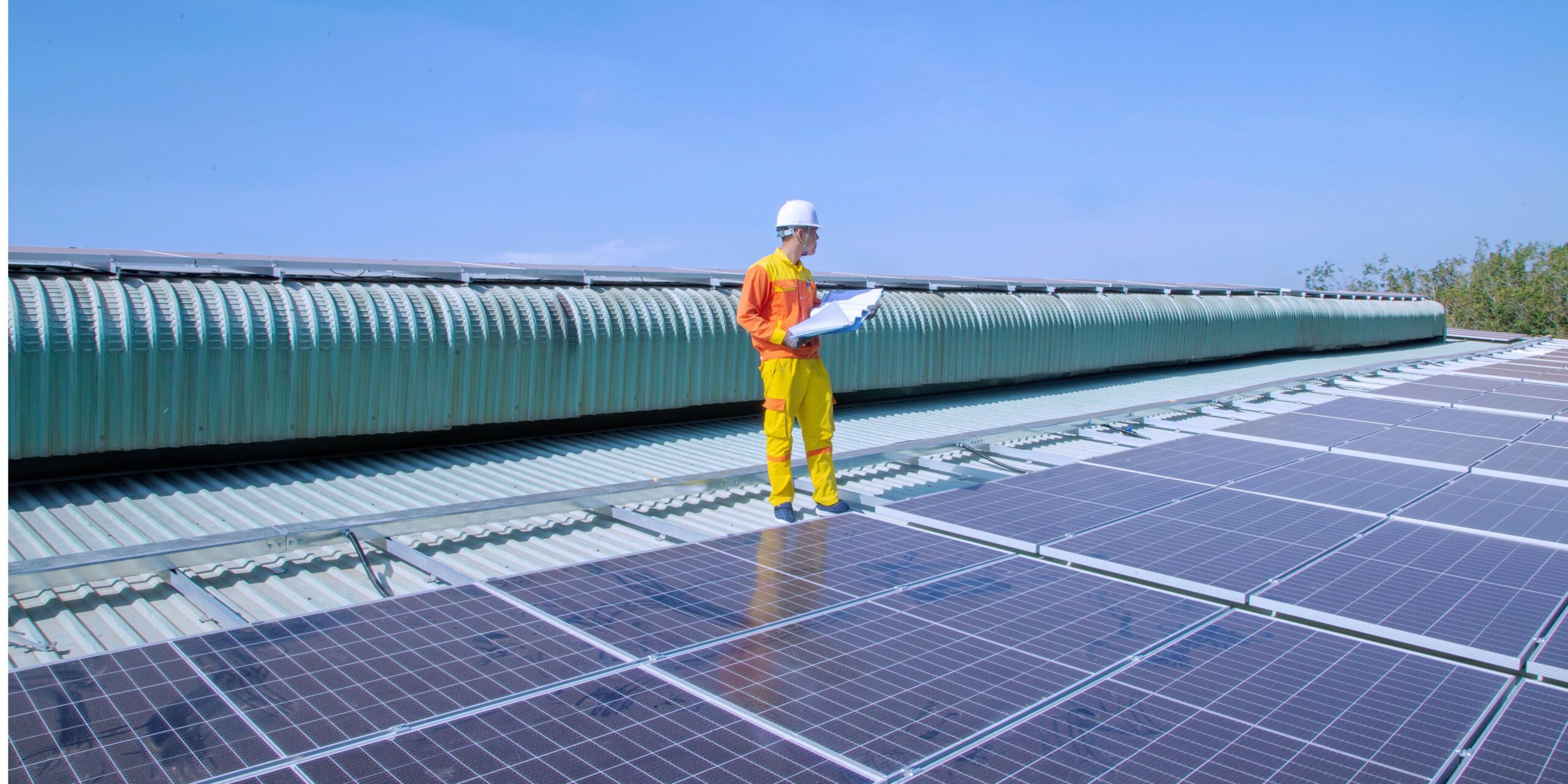 Adviseur inspecteert zonnepanelen op een bedrijfsgebouw in het kader van de energiebesparingsplicht.