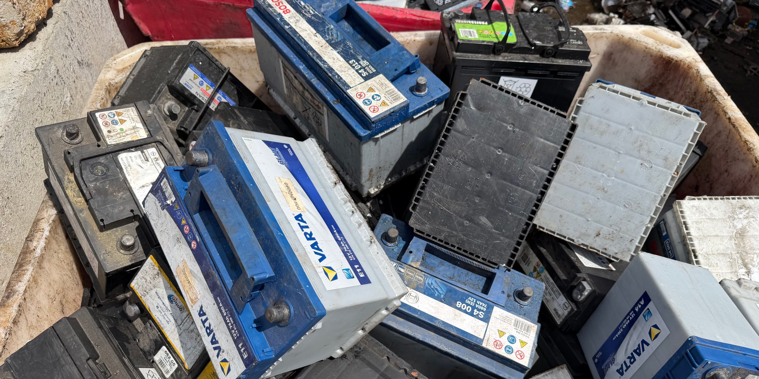 Afgedankte batterijen en accu’s in een afvalcontainer